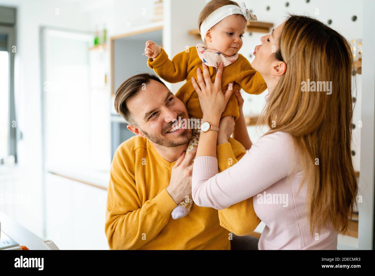 Happy family mother and father playing with a baby at home Stock Photo