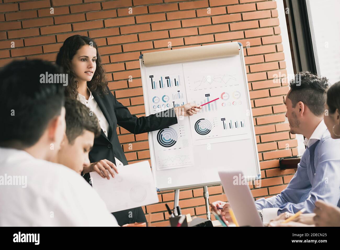 Business woman leader explaining and presenting sales statistic to her team in the meeting Stock Photo