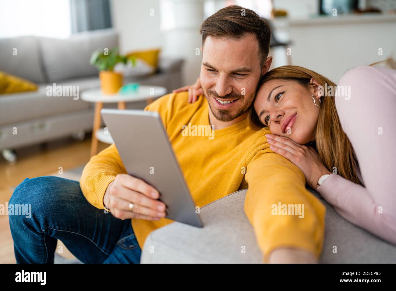Happy cheerful couple in love using digital tablet at home Stock Photo