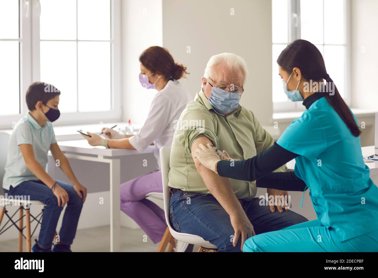 Nurses giving flu shots to older adults and children during vaccination