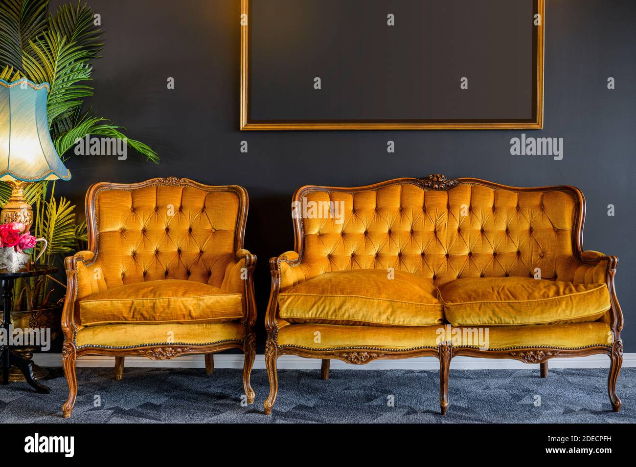 Image of old style, gold yellow chair and sofa in dark grey room Stock Photo