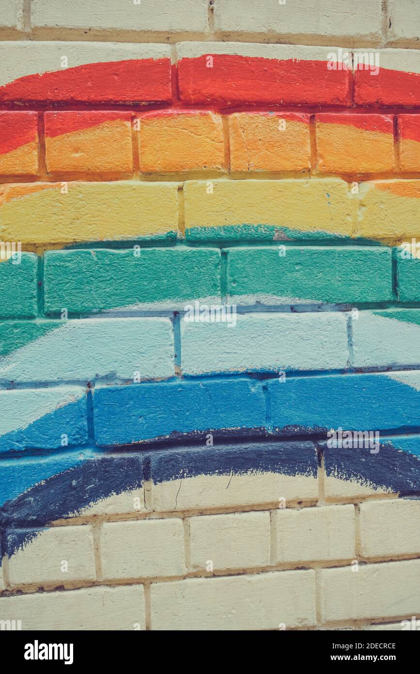 An image of the Rainbow flag painted on a brick wall in an urban ...