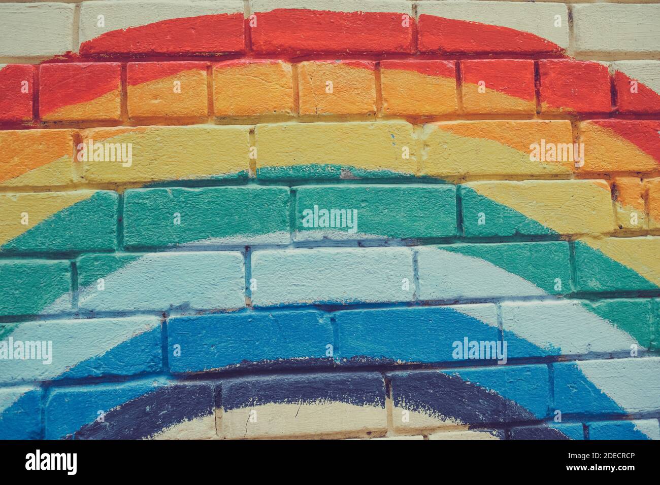 An image of the Rainbow flag painted on a brick wall in an urban ...