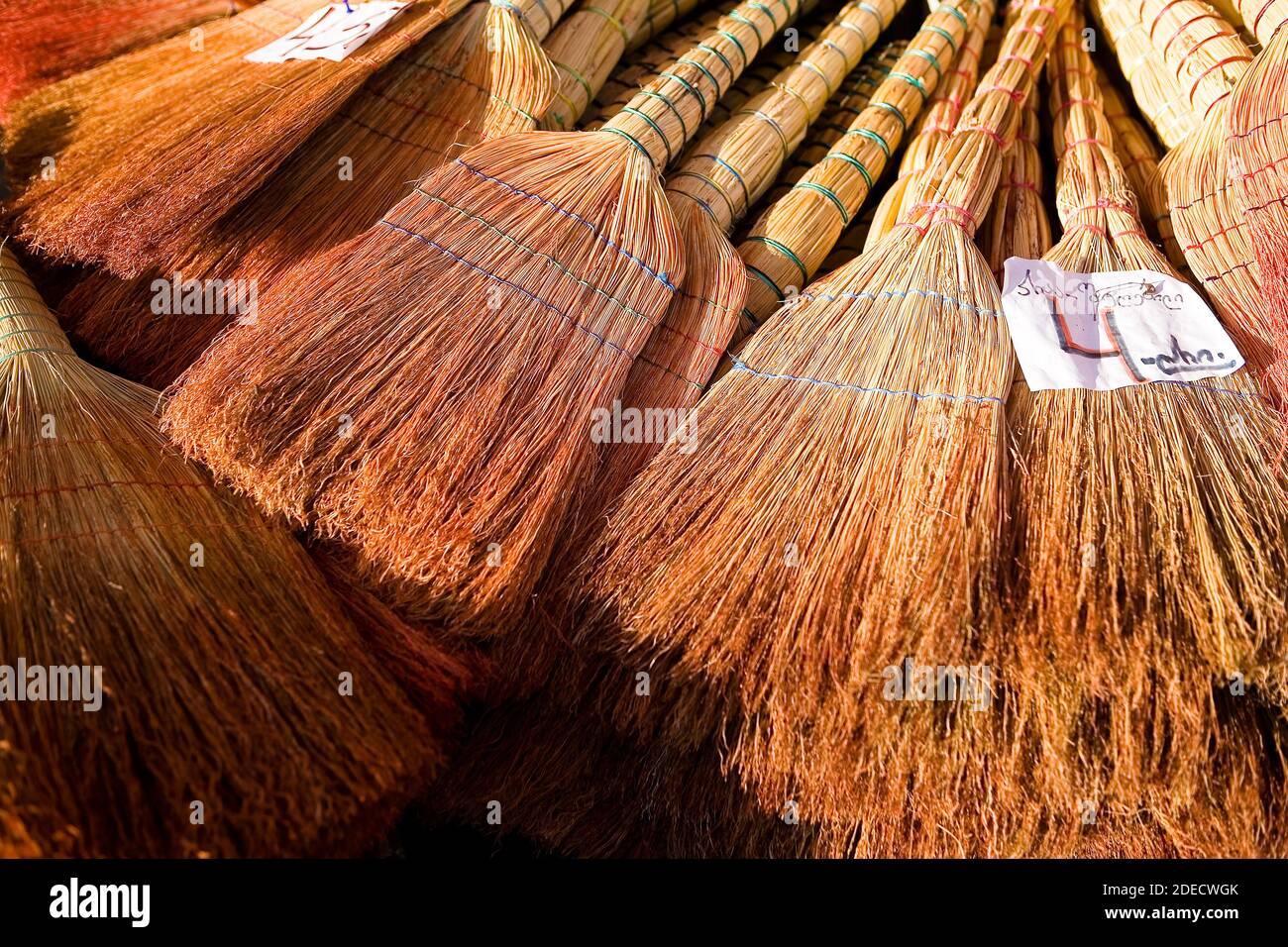 A lot of brooms for sale, on top of them lies the price tag. Georgia. Stock Photo