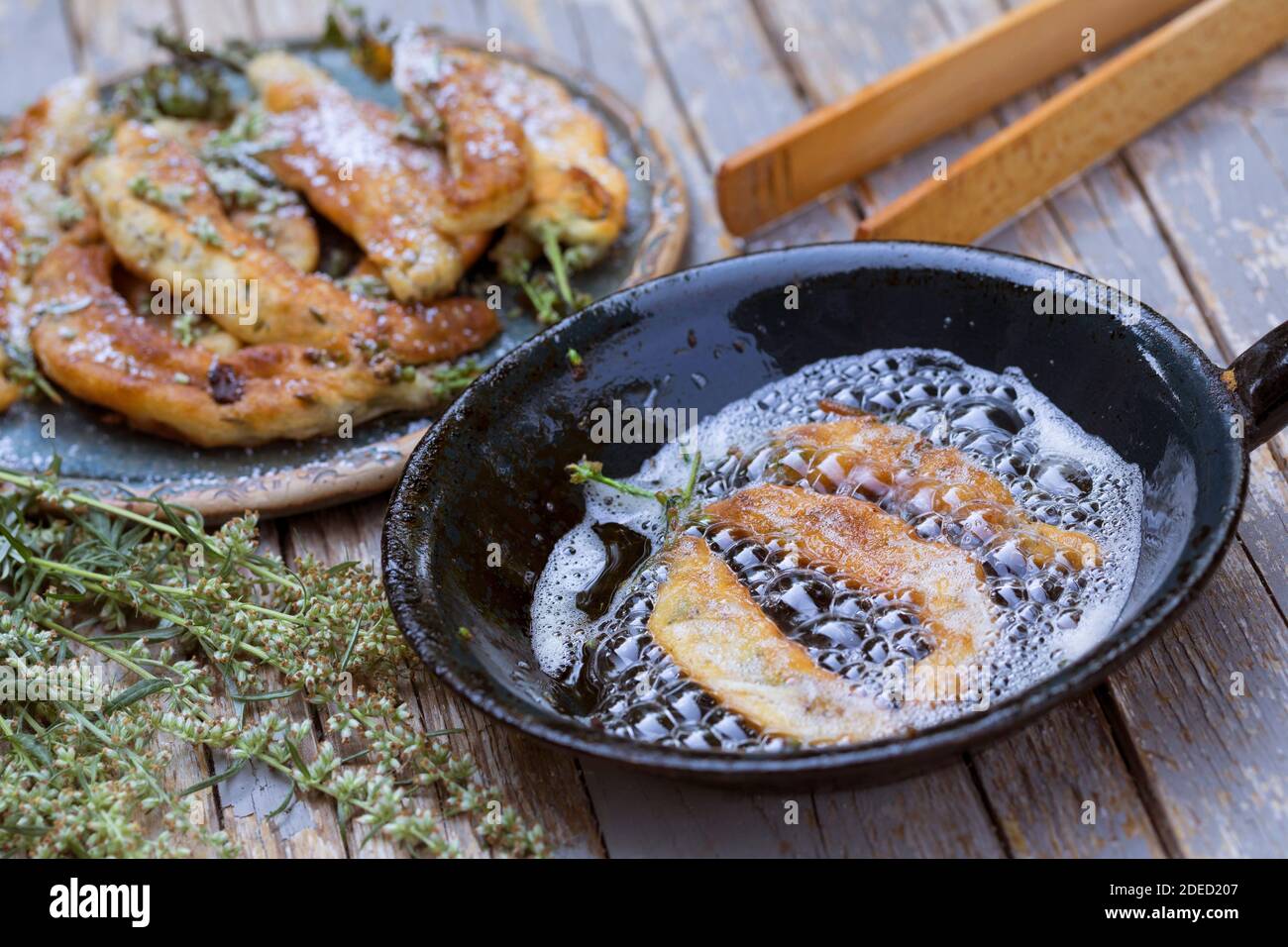 common mugwort, common wormwood (Artemisia vulgaris), home-baked small mugwort cakes, blossoms, leaves and sprout from wormwood are dipped in pancake Stock Photo