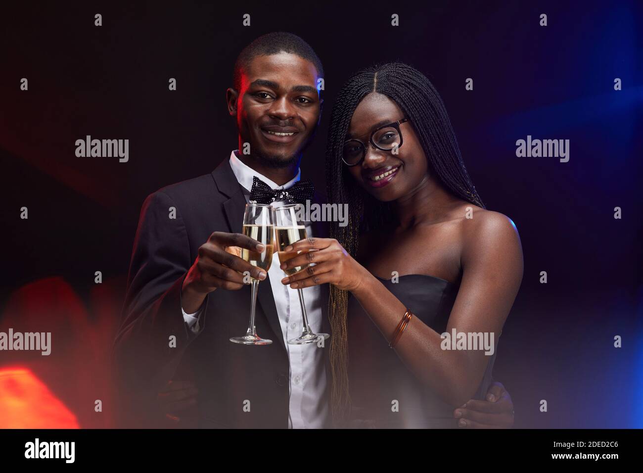 Waist up portrait of elegant African-American couple clinking champagne ...