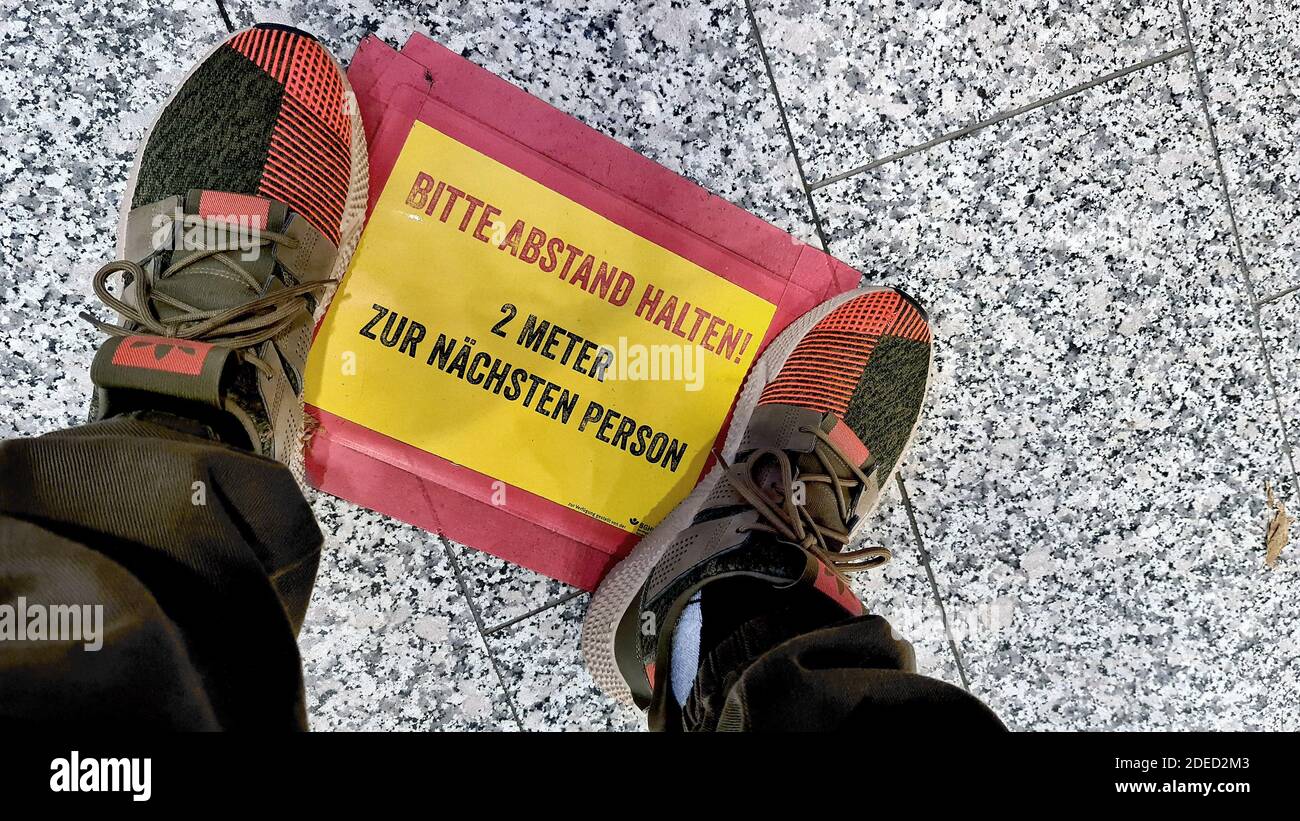 man standing on a sign on the ground, keep distance, Germany Stock Photo