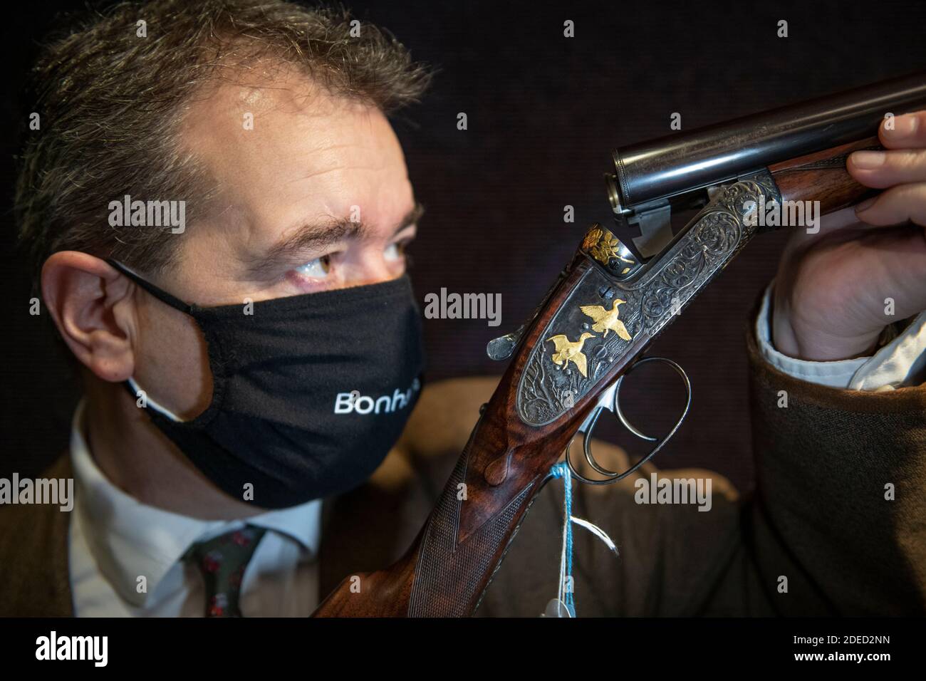 Knightsbridge, London, UK. 30 November 2020. Preview of Bonhams' Antique Arms, Modern Sporting Guns & Exceptional Firearms sale in London. The sale will be held on 3 December. Image: Bonhams staff looks along the bore of one of a pair of Ken Hunt decorated 12-bore self-opening sidelock ejector guns by J. Purdey & Sons, completed in 1968. Hunt was born in 1935 and at the age of 15 became an engraving apprentice with Purdey's under the famous Harry Kell. In 1963 he went into business in his own right, working until his retirement in 2011. Estimate: £35,000-55,000. Credit: Malcolm Park/Alamy Live Stock Photo