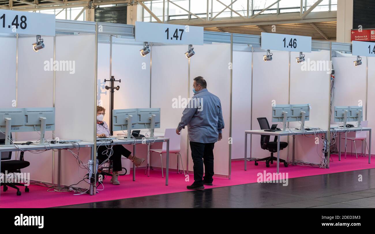 Munich, Germany. 30th Nov, 2020. Two employees work in the still empty Contact Tracing Center. The booths have been set up in Hall C2 of Messe Riem. Credit: Peter Kneffel/dpa/Alamy Live News Stock Photo