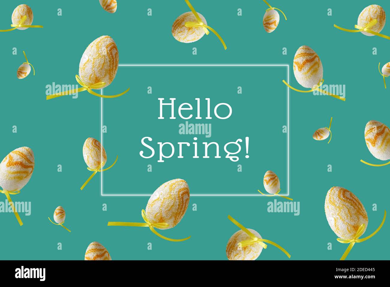 Hello spring hand lettering. Winter pattern with flying yellow eggs on turquoise background. Zero gravity concept. Stock Photo