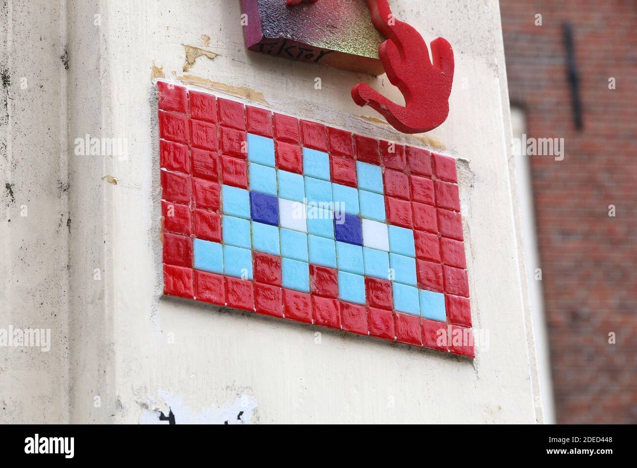 AMSTERDAM, NETHERLANDS - JULY 8, 2017: Space Invaders urban art mosaic in Amsterdam. The video game themed tile artwork was created in many cities by Stock Photo