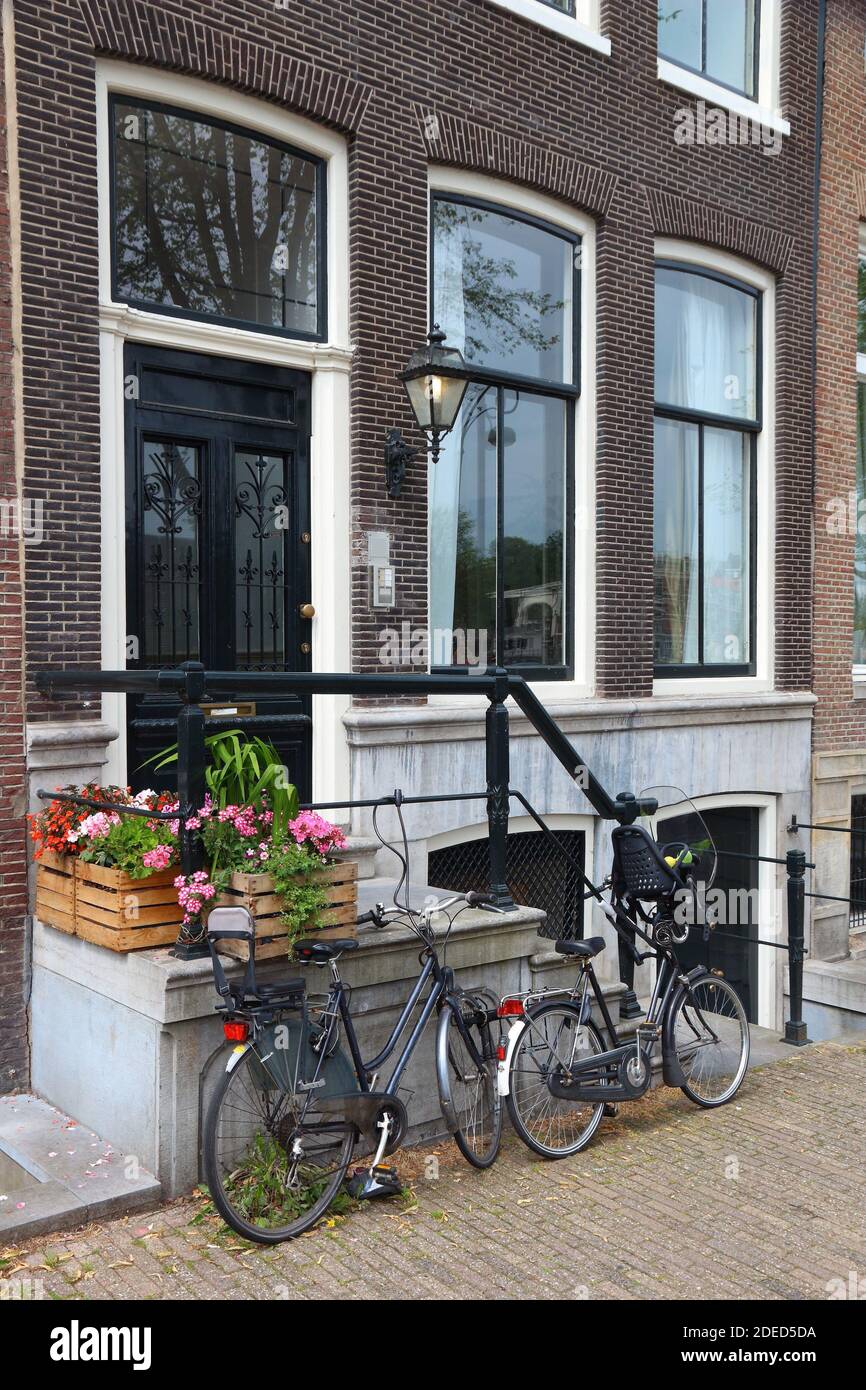 Amsterdam residential street - generic old house ornate door. Netherlands rowhouse. Parked bicycles. Stock Photo