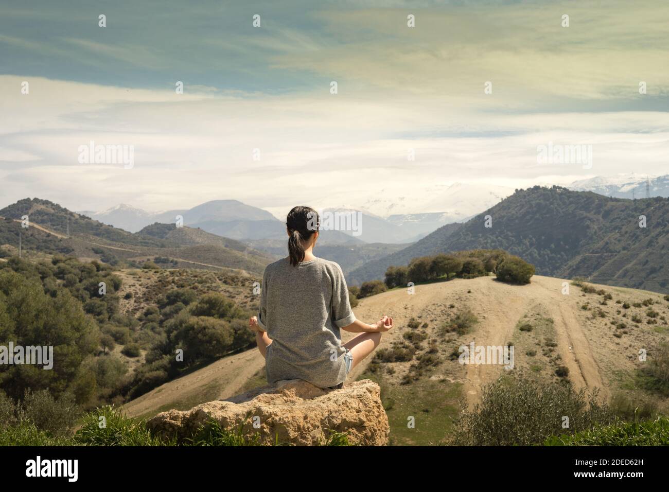 Young womanmeditating in front of Sierra Nevada Mountain Stock Photo