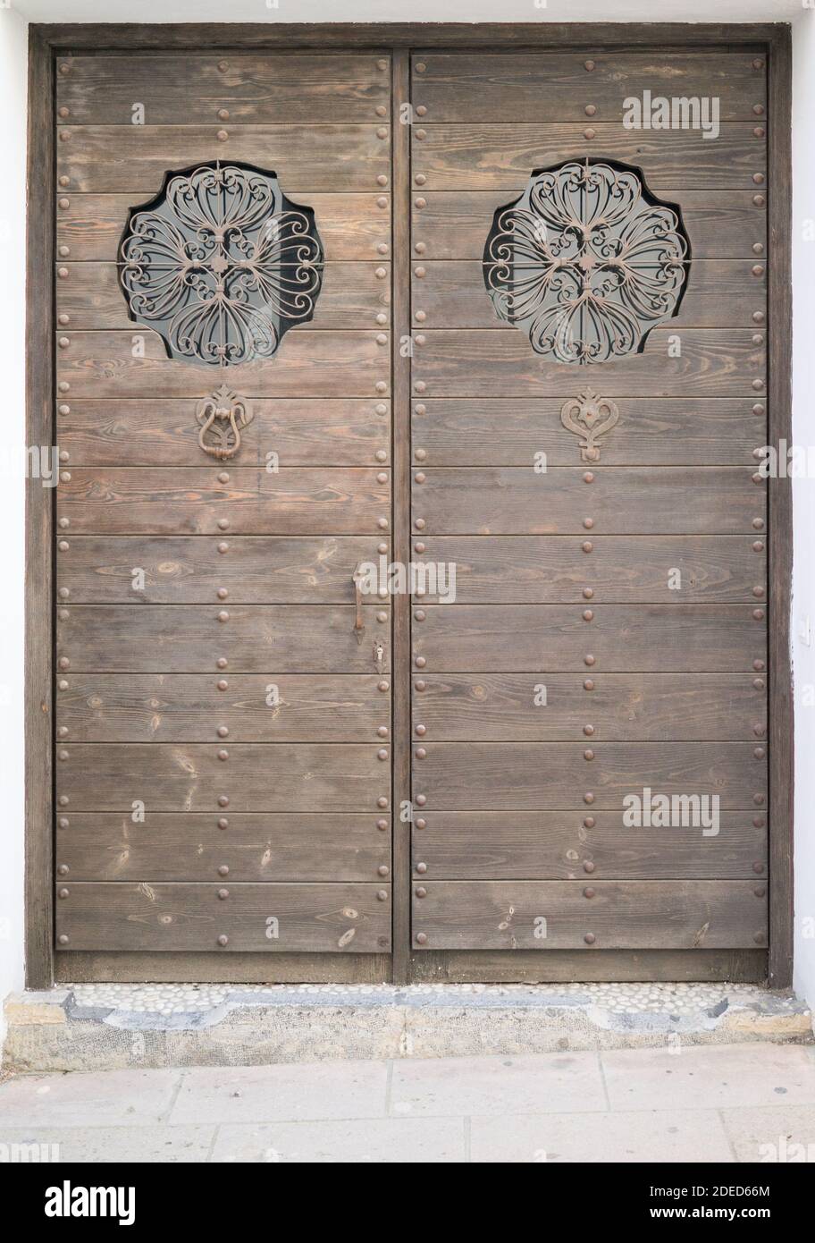 old brown double wooden door decorated with metal and glass Stock Photo