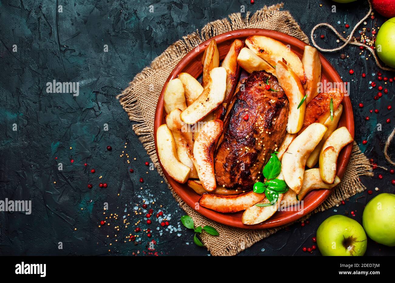 Fried pork tenderloin with quince, dark background, top view Stock