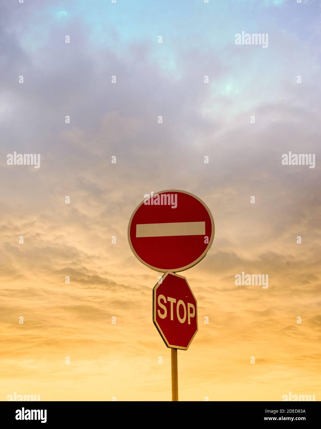 Road sign in sunset clouds wrong way stop Stock Photo