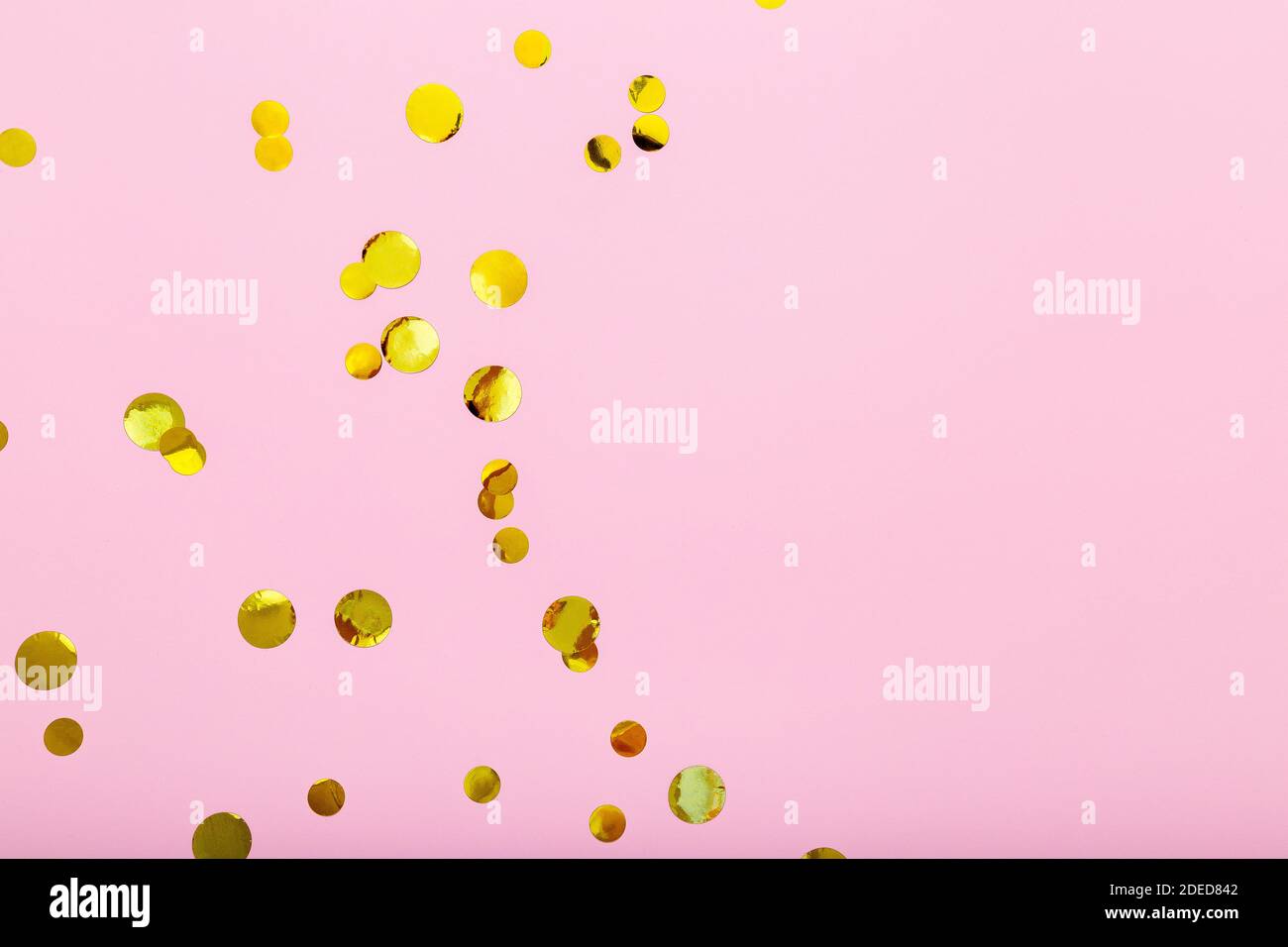Gold confetti sparkles frame on pink background. Flat lay, top view festive backdrop with copy space. Celebration concept. Stock Photo
