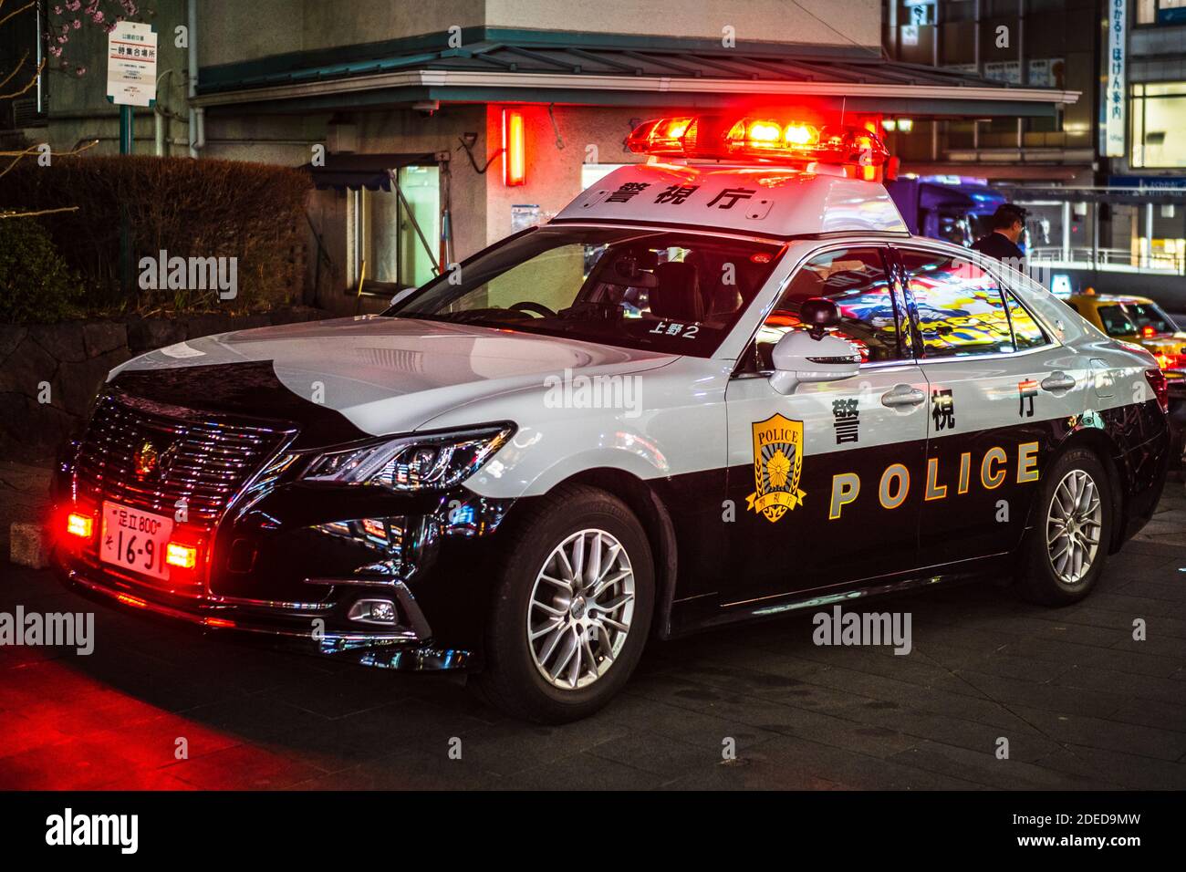 Japanese Police Car on a call - Tokyo Police Cruiser parked at a call with lights flashing. Police Car Japan. Police Car Tokyo Flashing Lights. Stock Photo