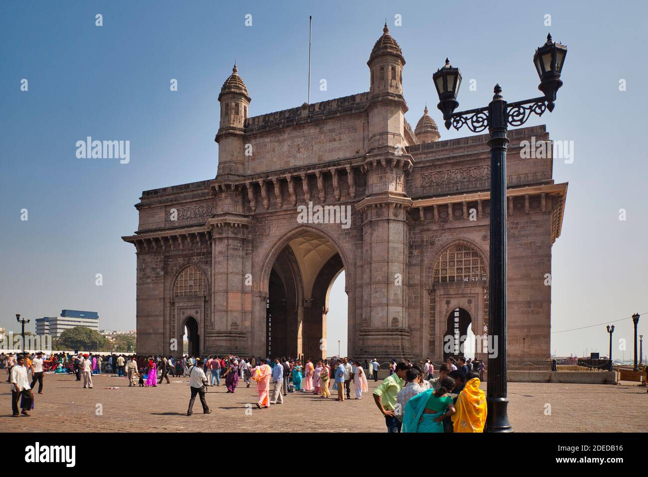 The famous stone building, monument and archway known as The Gateway of India in Mumbai, Maharashtra, India, with people milling around Stock Photo