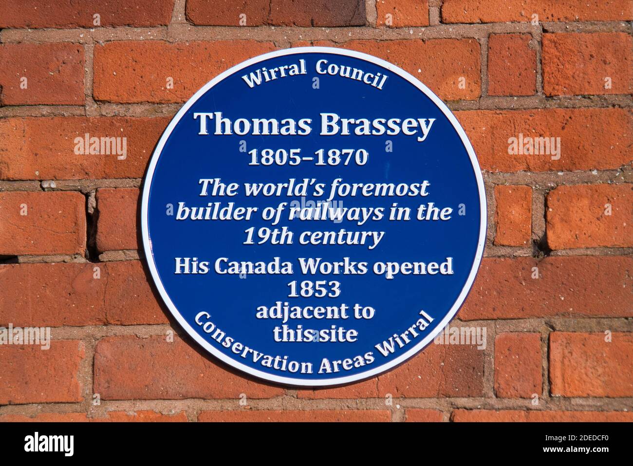 A commemorative blue plaque marking the location of the Canada Works site in Birkenhead, Wirral, UK, of the engineering contractor Thomas Brassey Stock Photo - Alamy