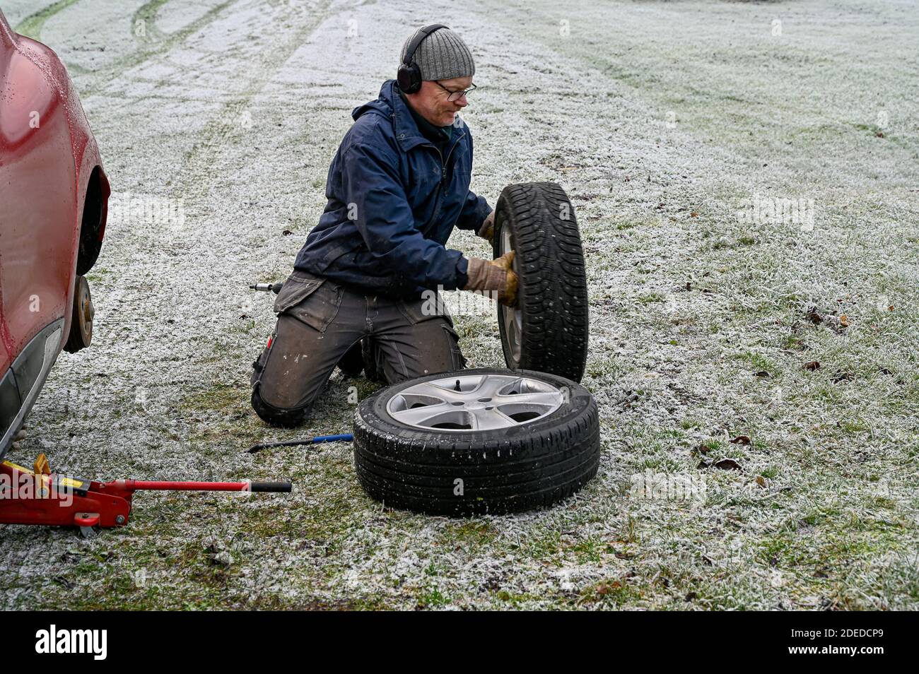 middle aged man changing tires at home Stock Photo Alamy