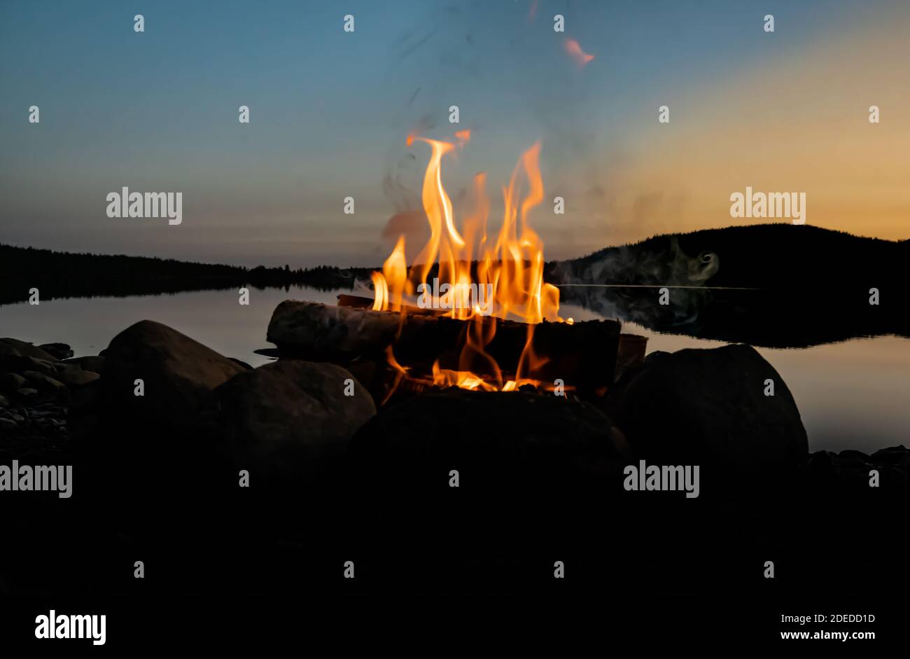 Cozy camp fire on the beach of a lake in the evening Stock Photo - Alamy