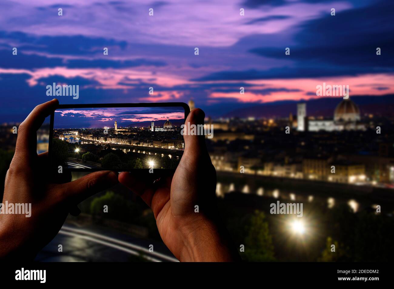 Tourist taking photo of Florence after sunset from Michelangelo square, Florence, Italy. Beautiful panoramic view of Duomo Santa Maria Del Fiore Stock Photo