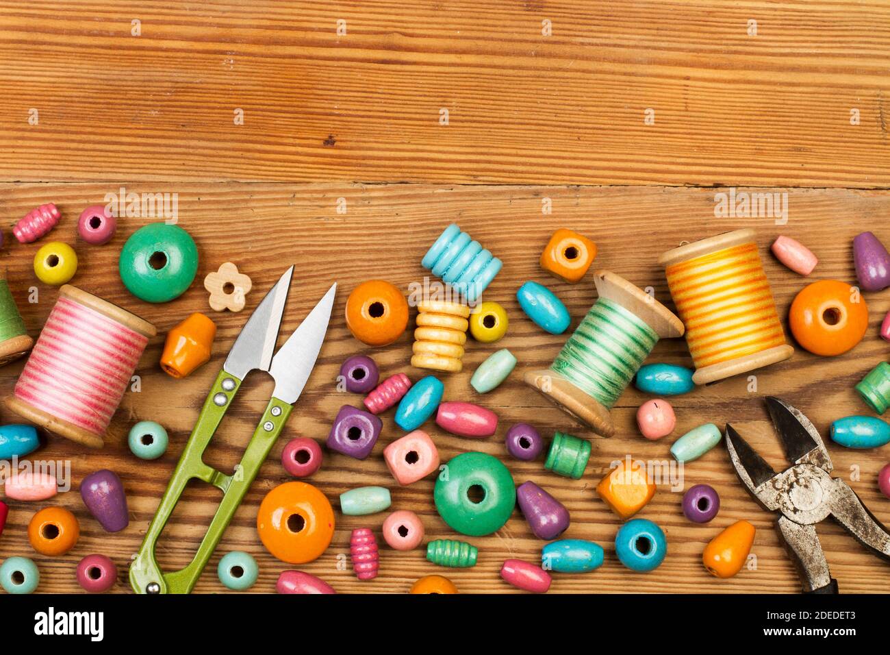 Colored wooden beads on a wooden table in a close up view with copy space Stock Photo