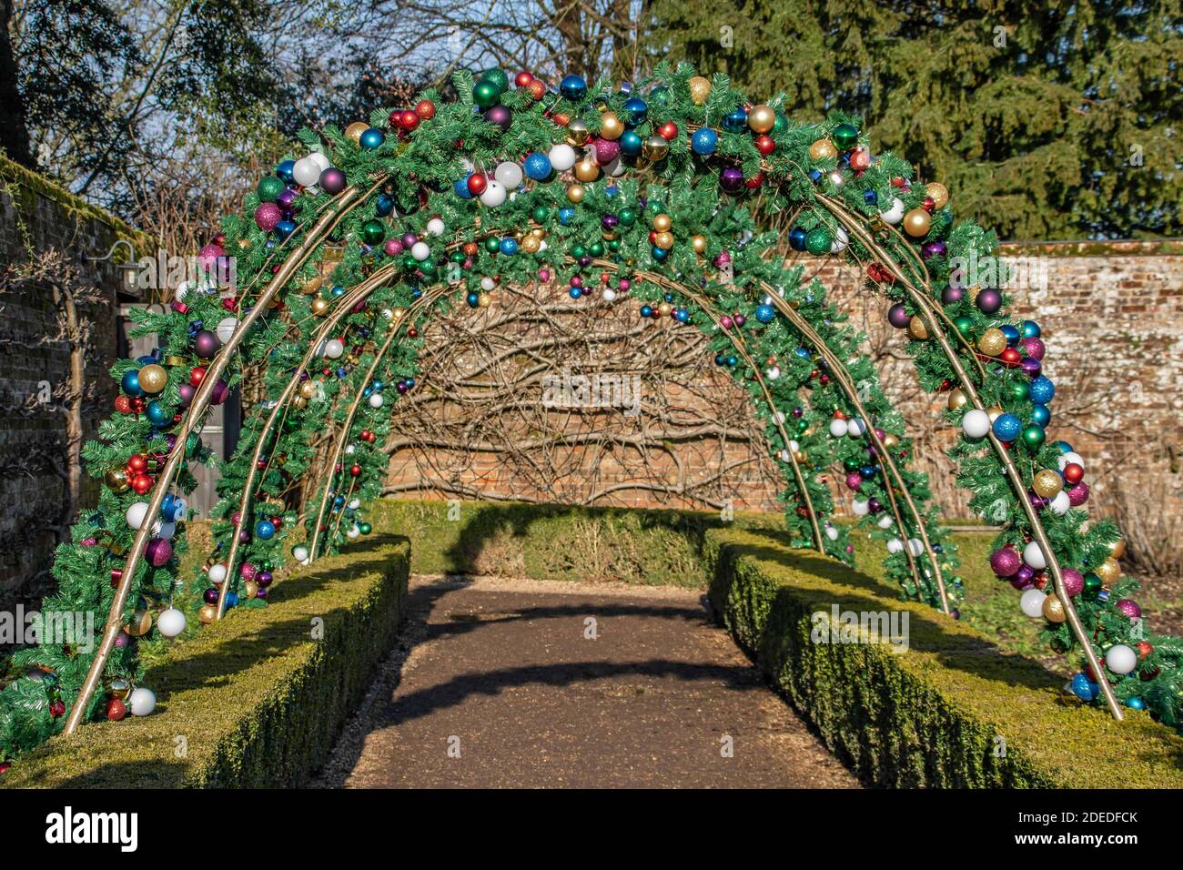 archway decorated with bright colourful christmas baubles Stock Photo
