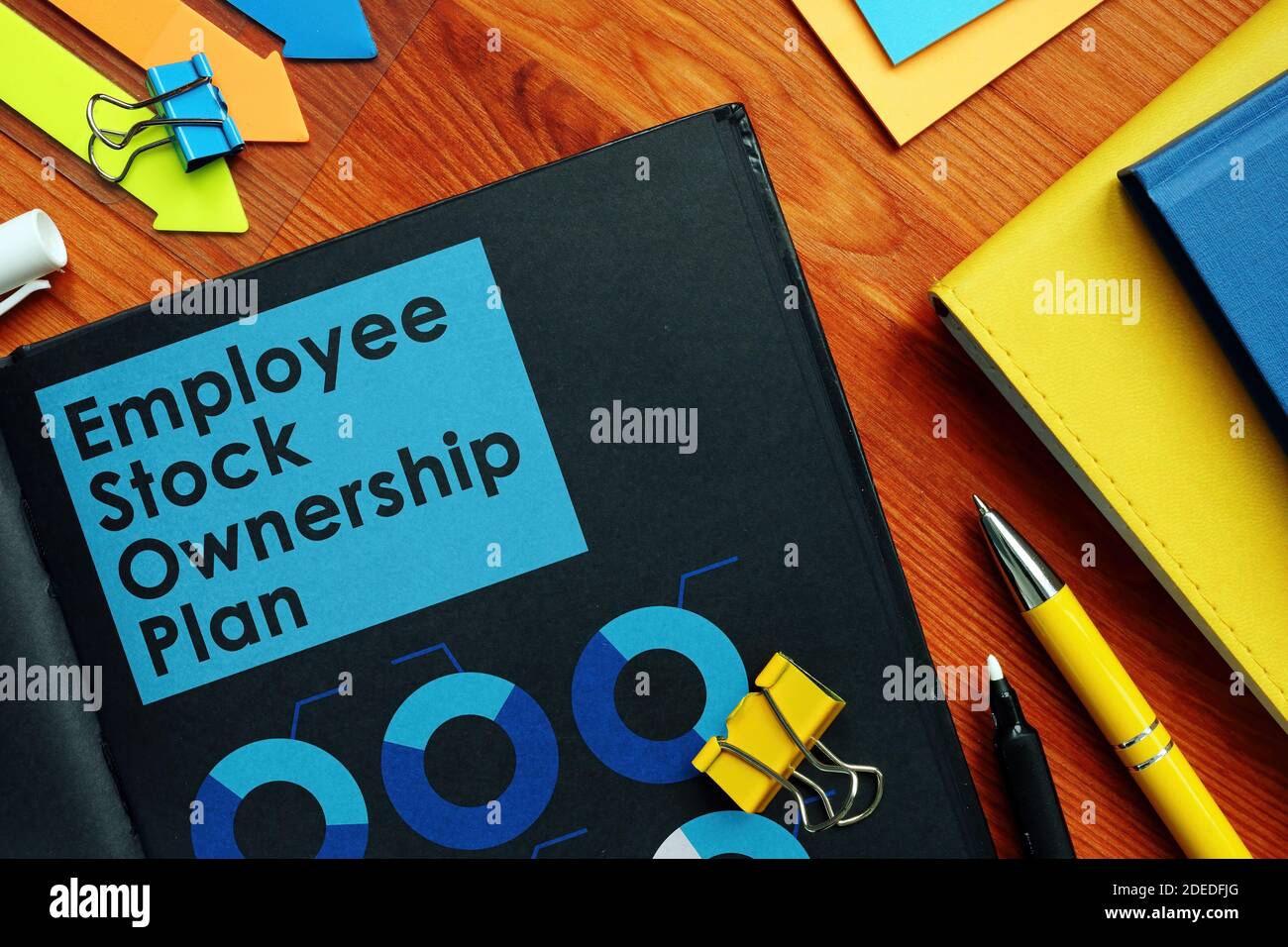 Employee Stock Ownership Plan ESOP and charts on the black pages. Stock Photo