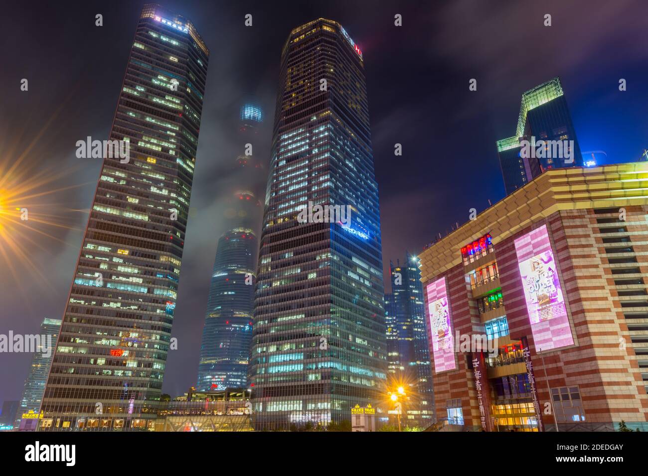 Night view of the skycrapers at Pudong new district in Shanghai at a cloudy day after raining with golden light in Shanghai, China Stock Photo