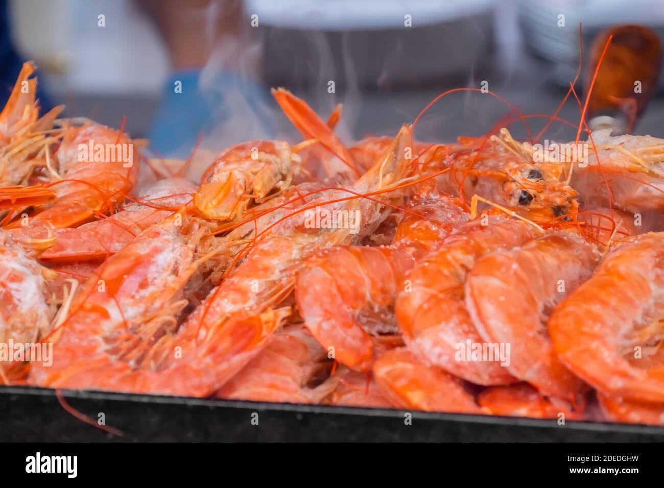 Process of cooking fresh red langoustine shrimps, prawns on grill