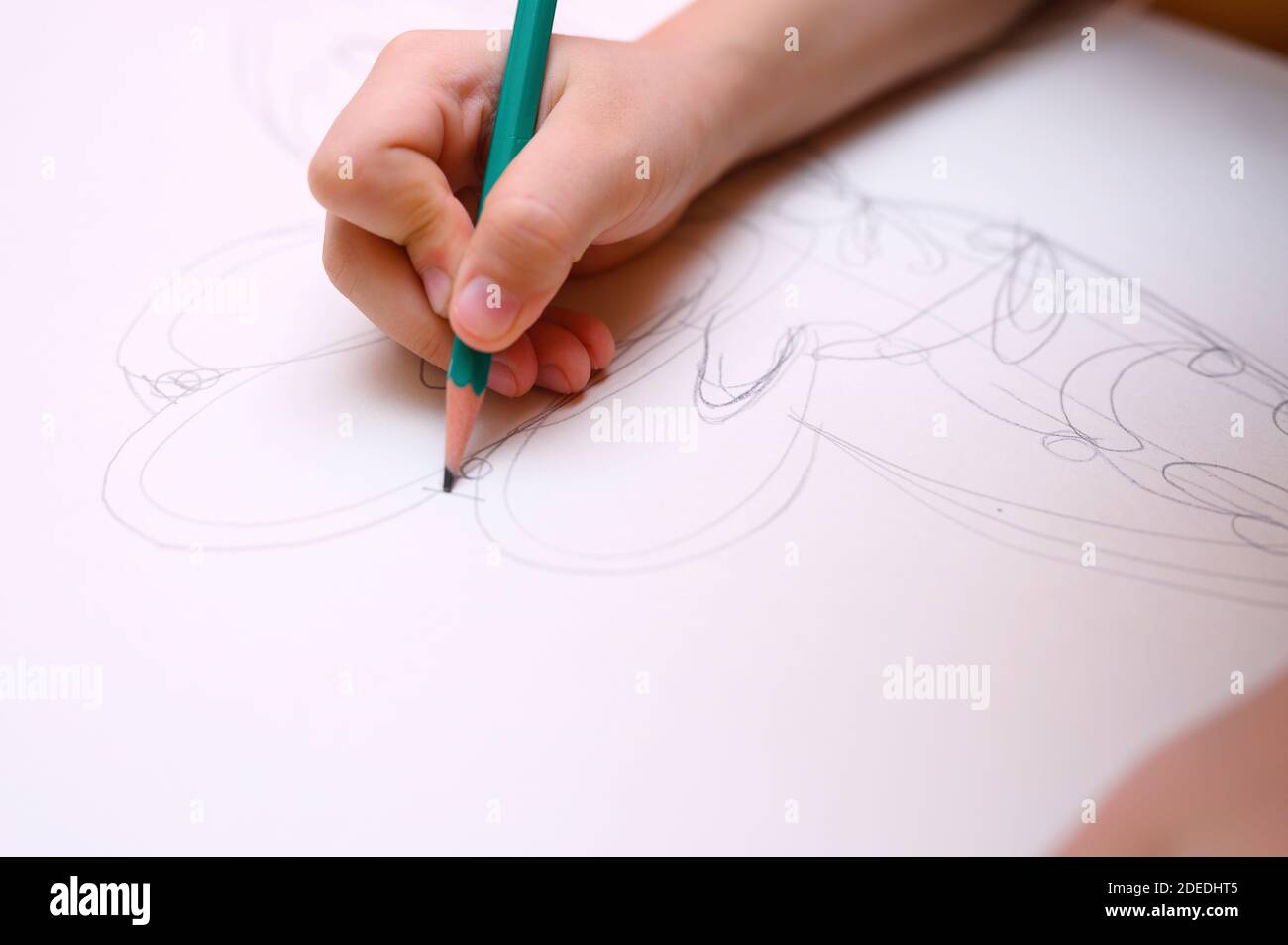 kids hobby. child hand draws sketch with a pencil on white paper Stock Photo