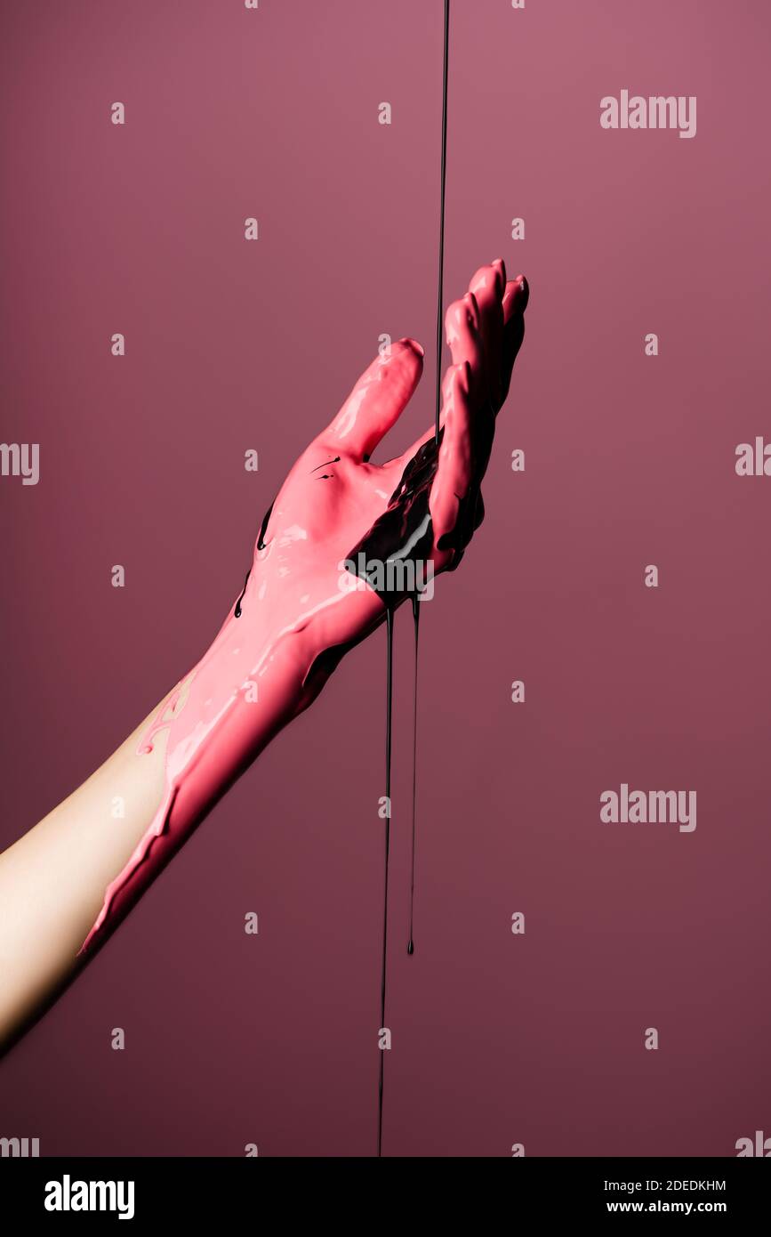 partial view of hand with dripping paint isolated on pink Stock Photo ...