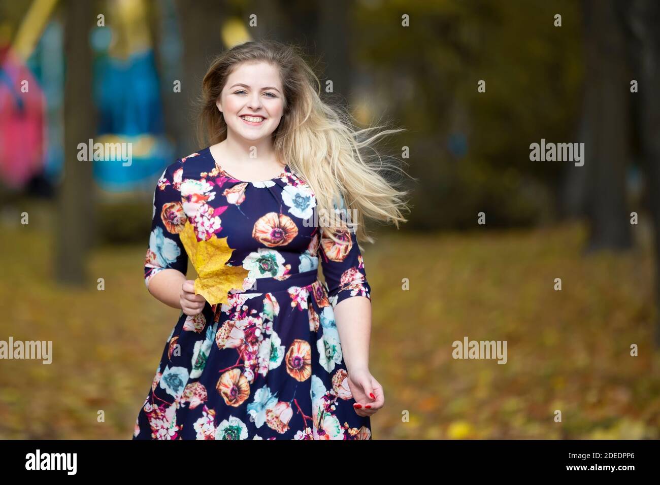 Happy blonde girl in autumn park with maple leaves Stock Photo - Alamy