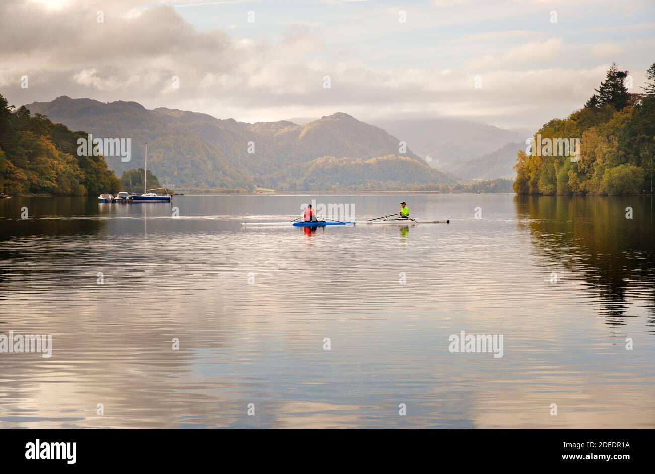 Leisure activity in the English Lake District two canoeists relax in the early morning reflections on Derwent Water near Keswick, Cumbria. Stock Photo