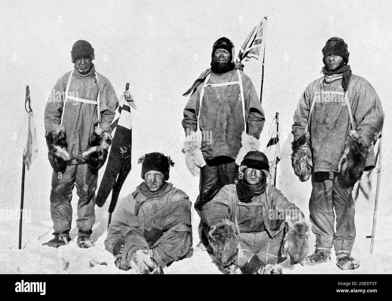 Robert Falcon Scott's Pole party of his ill-fated expedition, from left to right at the Pole: Oates (standing), Bowers (sitting), Scott (standing in front of Union Jack flag on pole), Wilson (sitting), Evans (standing). Bowers took this photograph, using a piece of string to operate the camera shutter.  17 January 1912 Stock Photo