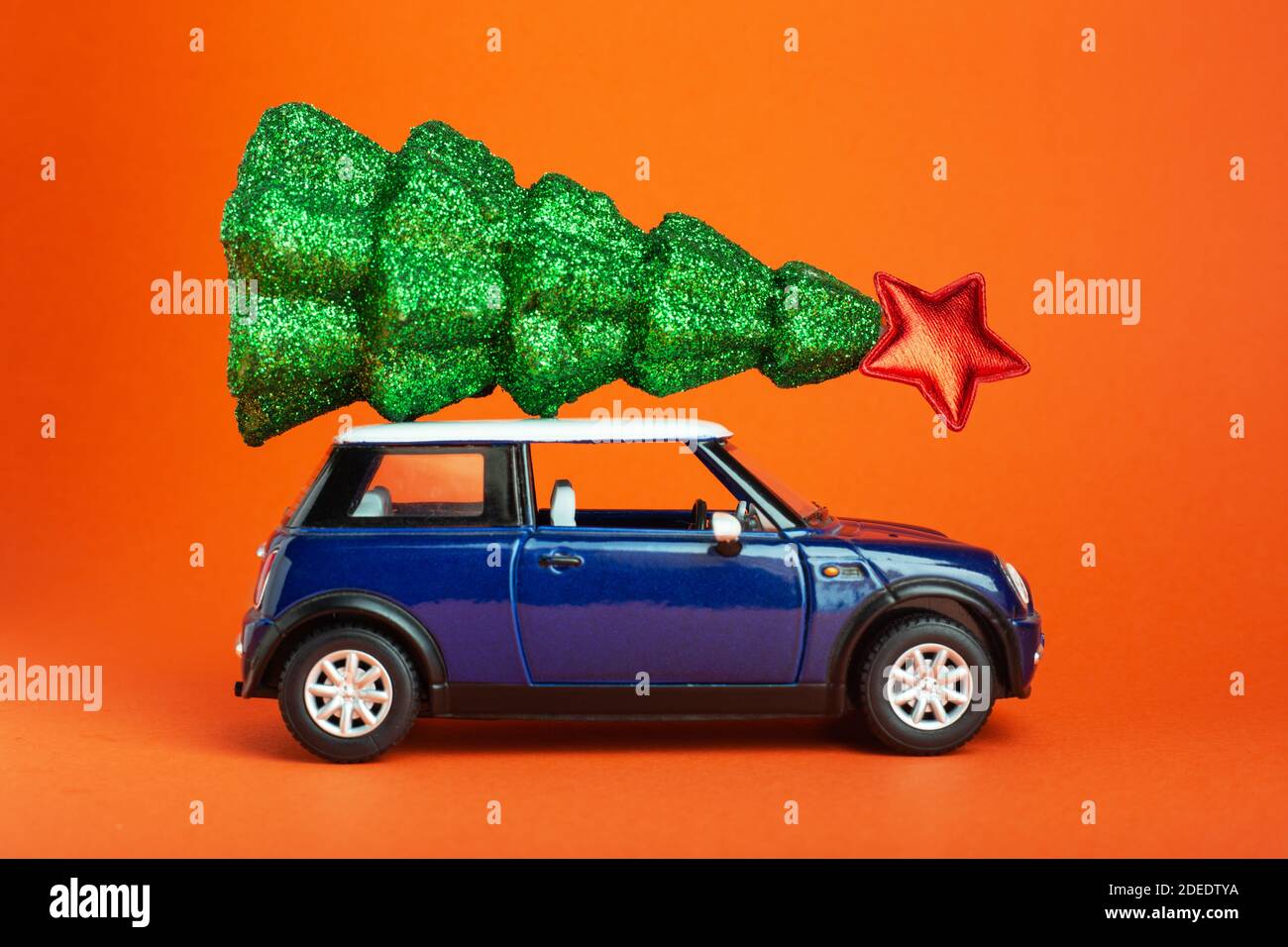 Christmas New Year tree with red star on top of blue car toy roof