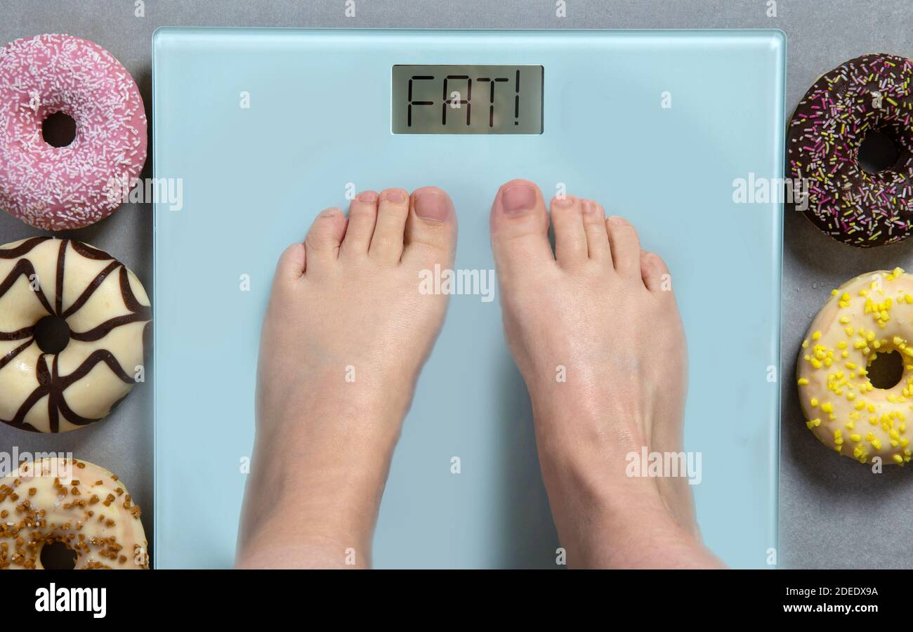 https://c8.alamy.com/comp/2DEDX9A/person-standing-on-digital-weight-scale-showing-the-words-fat-and-junk-food-donuts-on-background-diet-concept-2DEDX9A.jpg