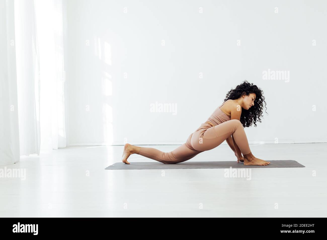 Beautiful woman brunette yoga asana stretching the flexibility of the body  fitness gym Stock Photo - Alamy