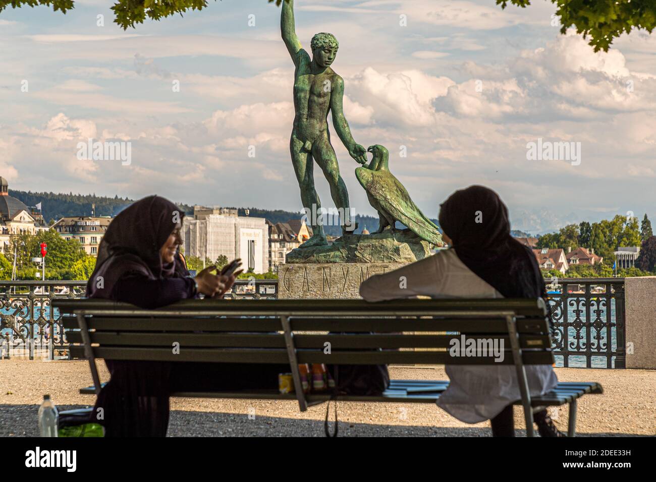 Headscarves relax in front of the Ganymede sculpture on the Bürkliterrasse in Zurich, Switzerland Stock Photo