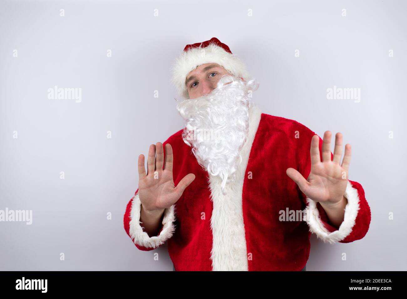 Man dressed as Santa Claus standing over isolated white background