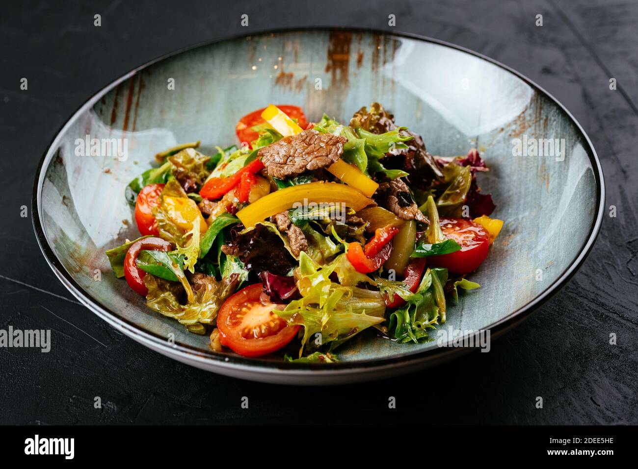 warm salad with marbled beef steak on a black background Stock Photo
