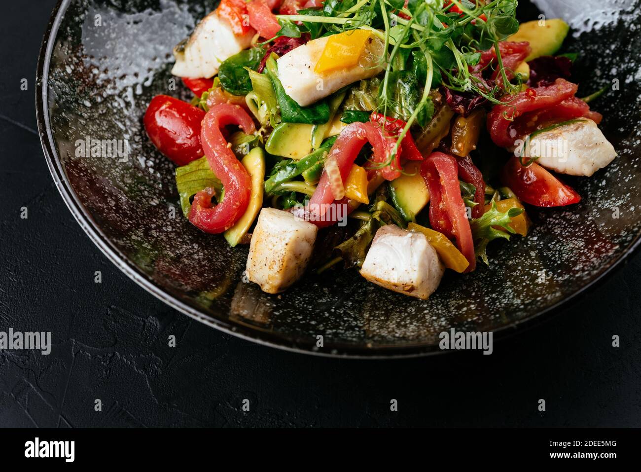 salad with shrimp, vegetables and crab meat on a black background Stock Photo
