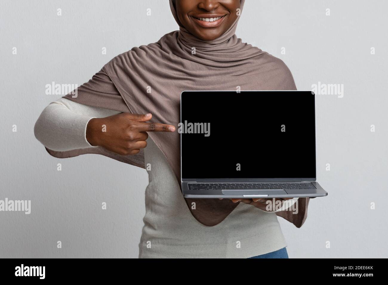 Download African Woman In Hijab Pointing At Laptop With Black Screen Mockup Image Stock Photo Alamy