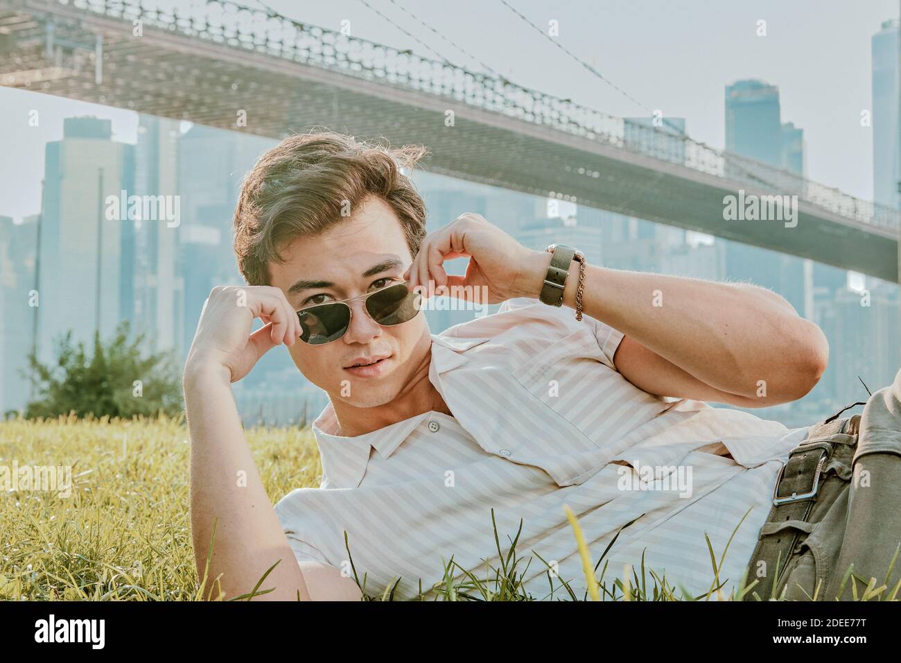 Young man sitting outdoors in park wearing sunglasses Stock Photo - Alamy