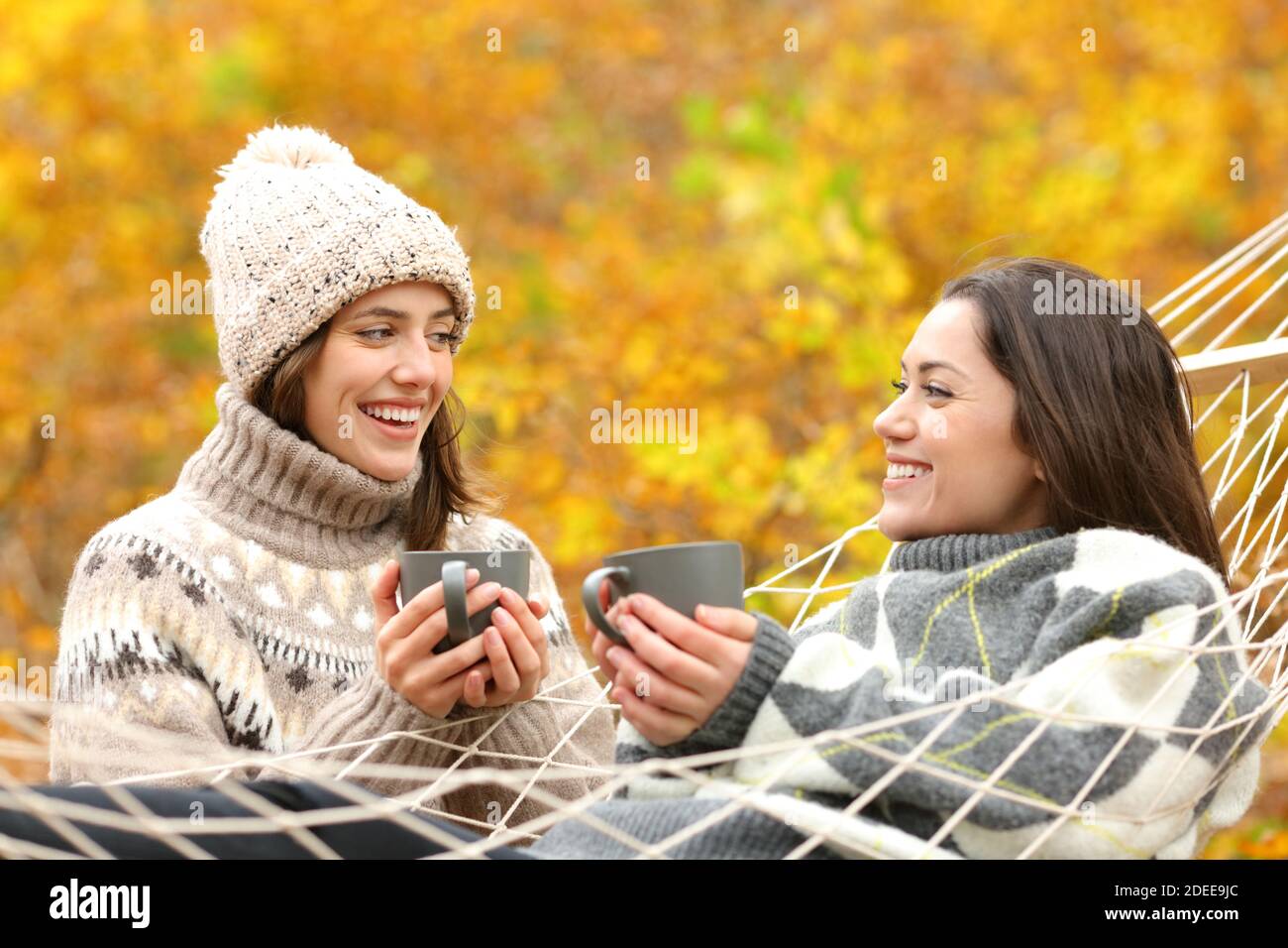 Two happy friends talking in autumn holiday in the mountain Stock Photo