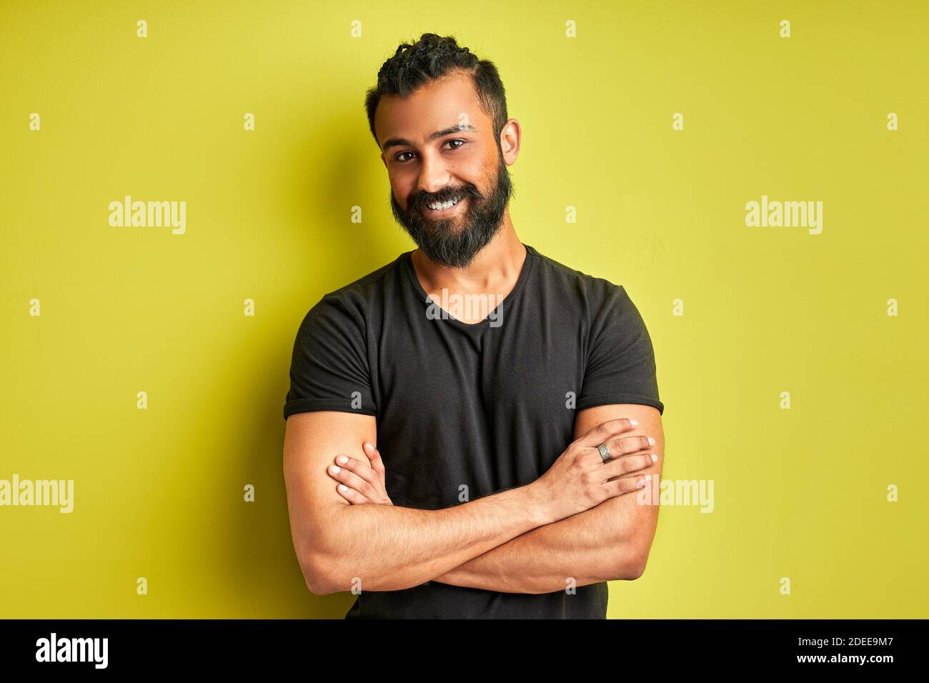 indian arab ith a happy and cool smile on face isolated on green studio background. portrait of lucky person, good mood Stock Photo
