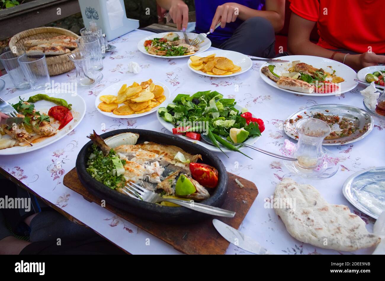 Plates with different Turkish food in a restaurant in a small village in mountains. Big variety of traditional local cuisine on table. Stock Photo