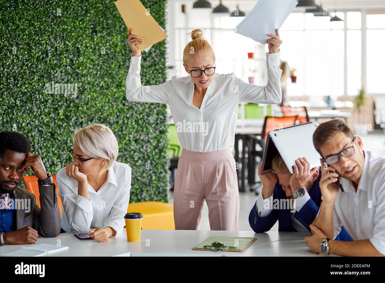 furious female director dissatisfied with work, she yells at emplyees holding papers documents in hands, bad work concept Stock Photo